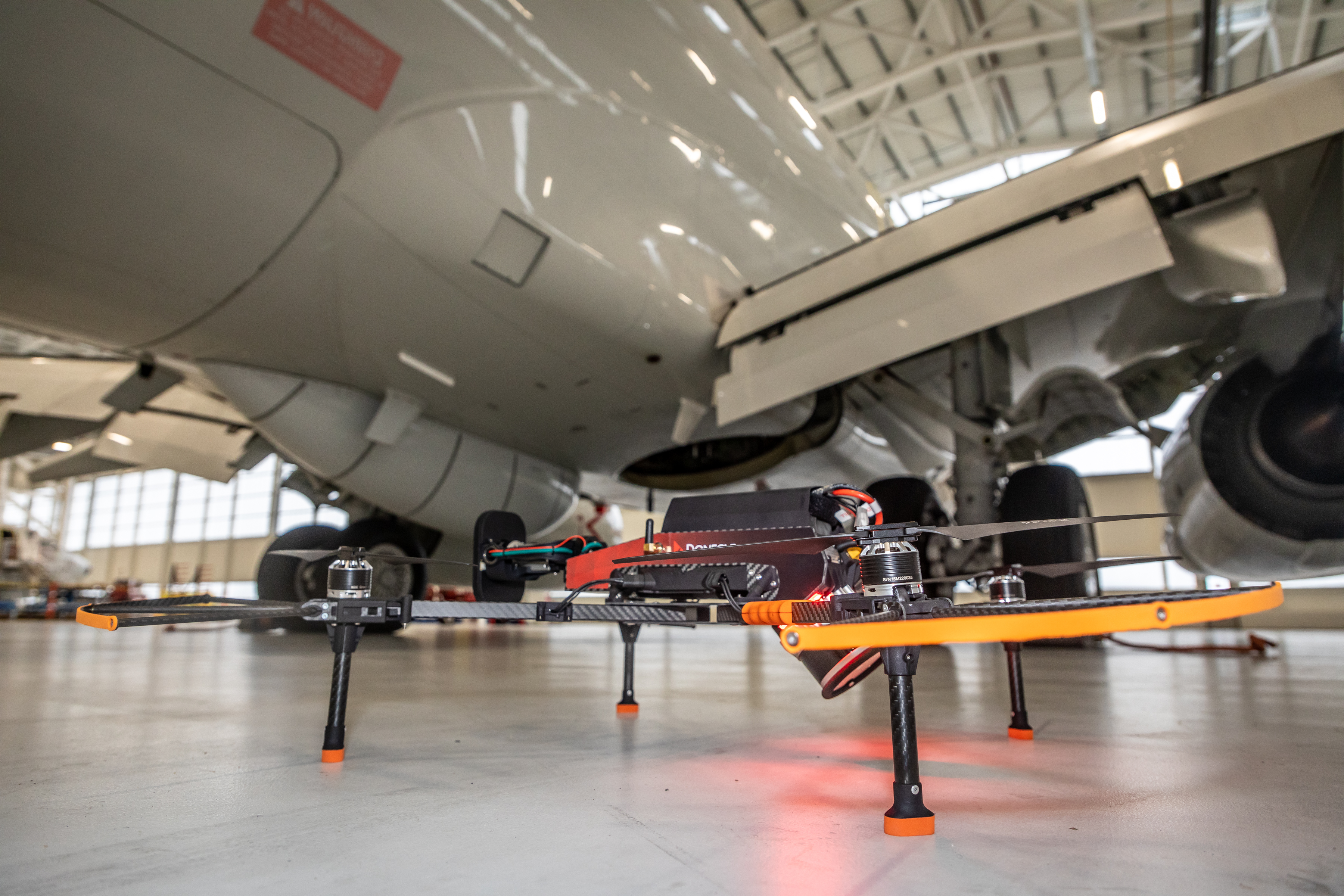 The specialist drone in front of an aircraft in a hangar